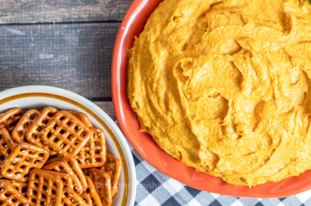 pumpkin pie dip in bow next to square pretzels