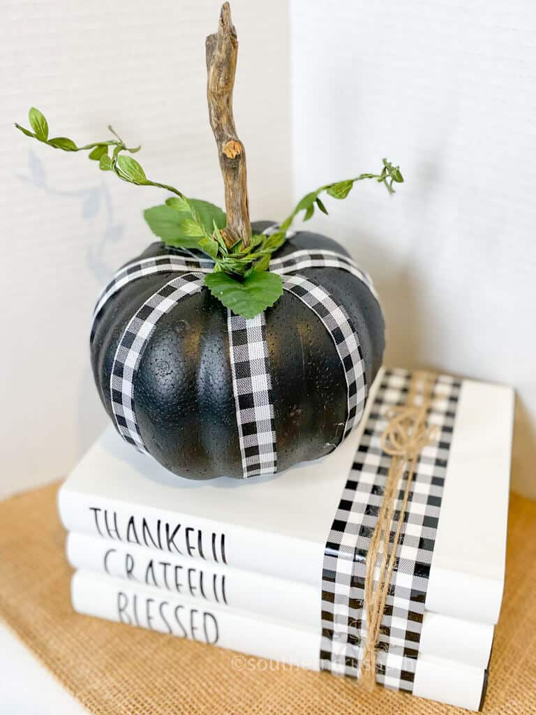 black and white pumpkin on book stack