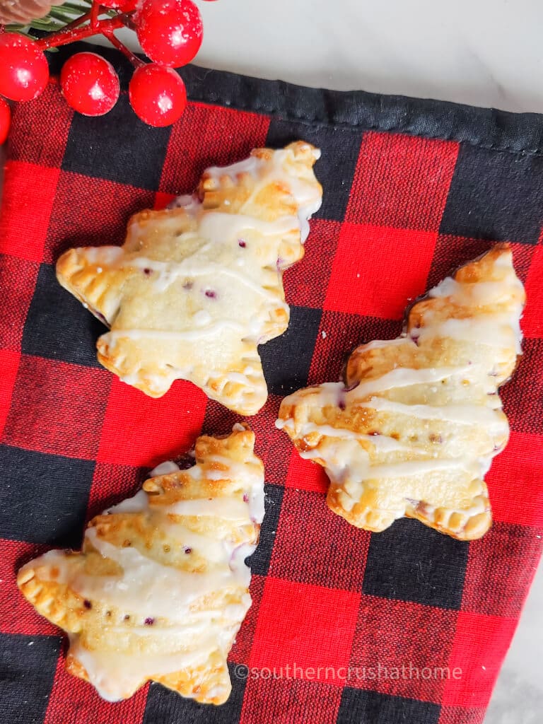 three blueberry hand pies on buffalo plaid towel