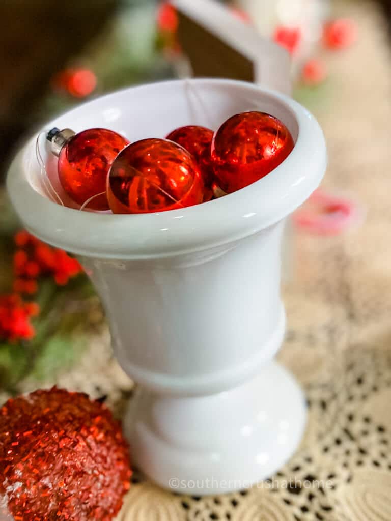 milk glass vase with red lighted balls