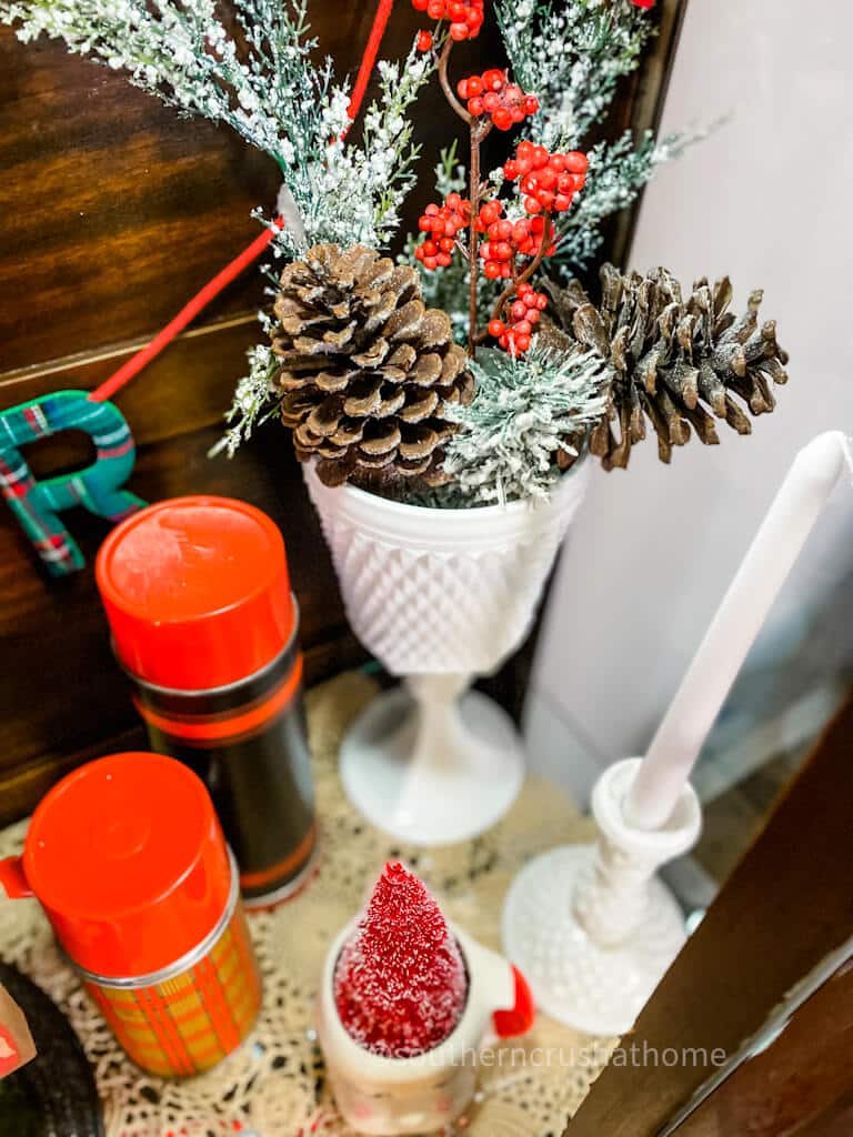 milk glass with pinecones and faux fir branches