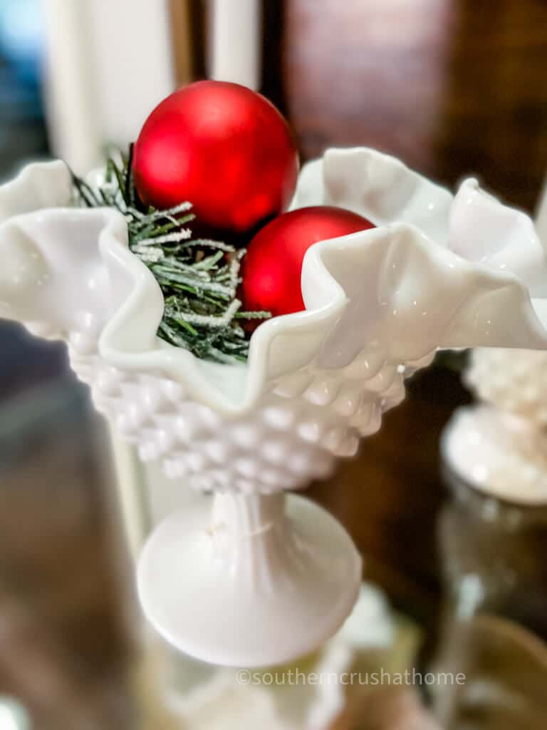 milk glass with red vintage ornaments