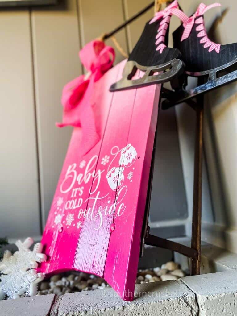 side view of pink christmas snow sled with skates and bow