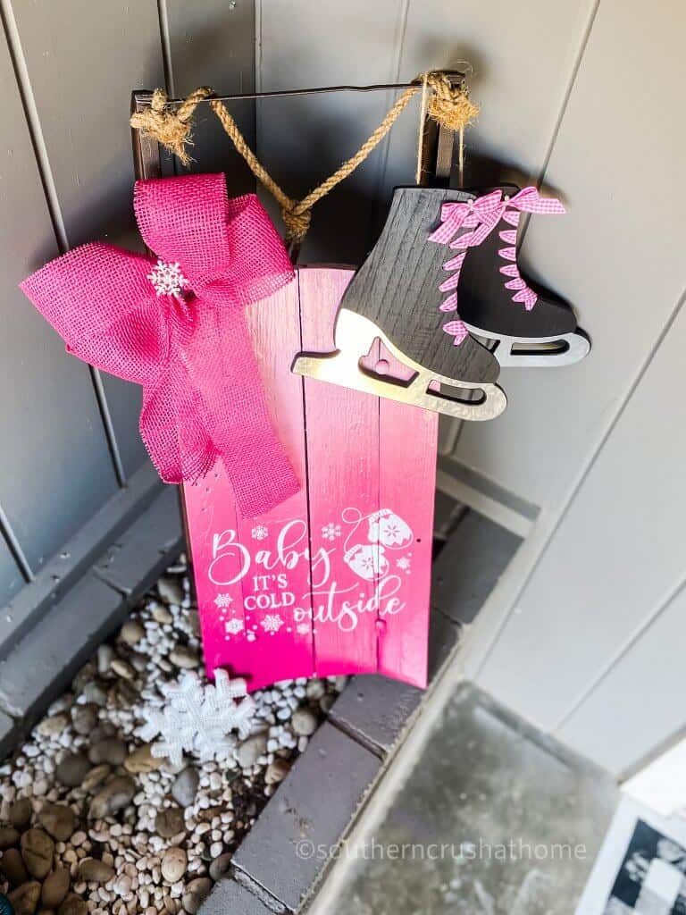 overhead view of pink christmas snow sled with skates and bow