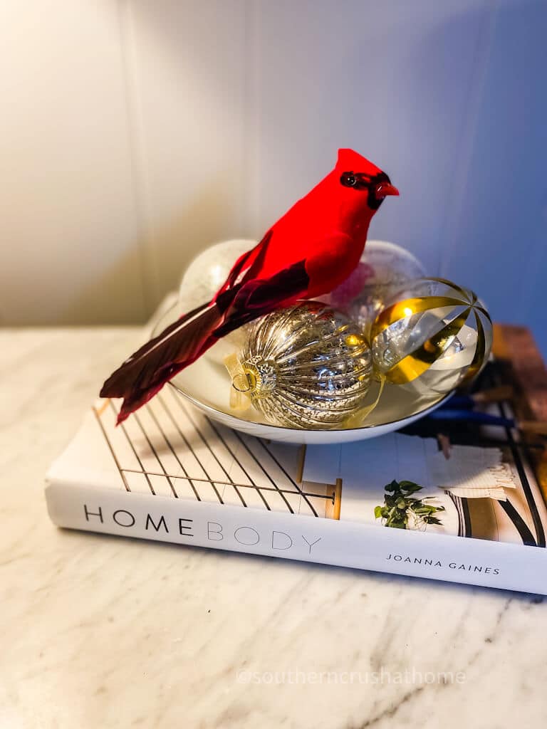 red cardinal in bowl of christmas ball ornaments