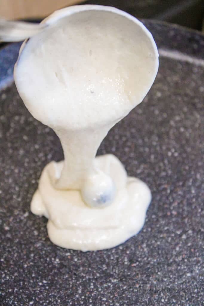 pouring cup of eggless pancake batter