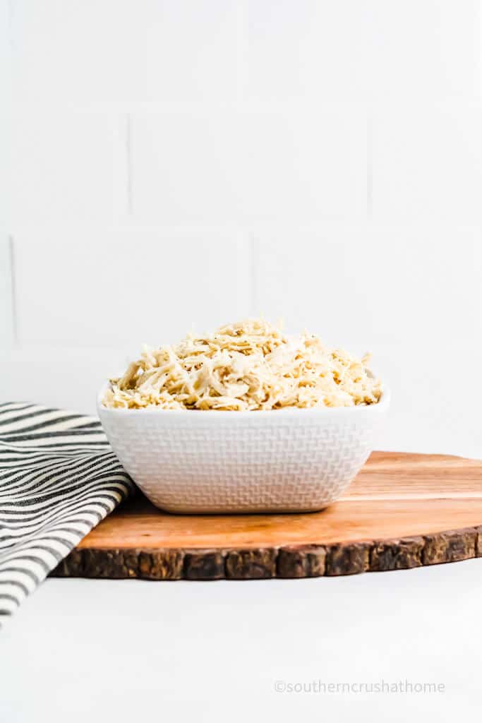 bowl of shredded chicken on wood slice