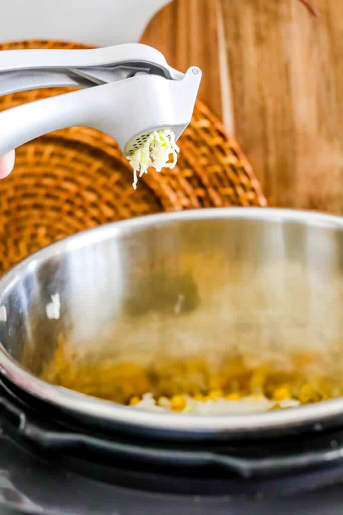 squeezing garlic through garlic press