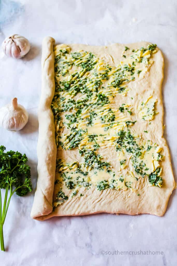 garlic butter mixture spread onto dough