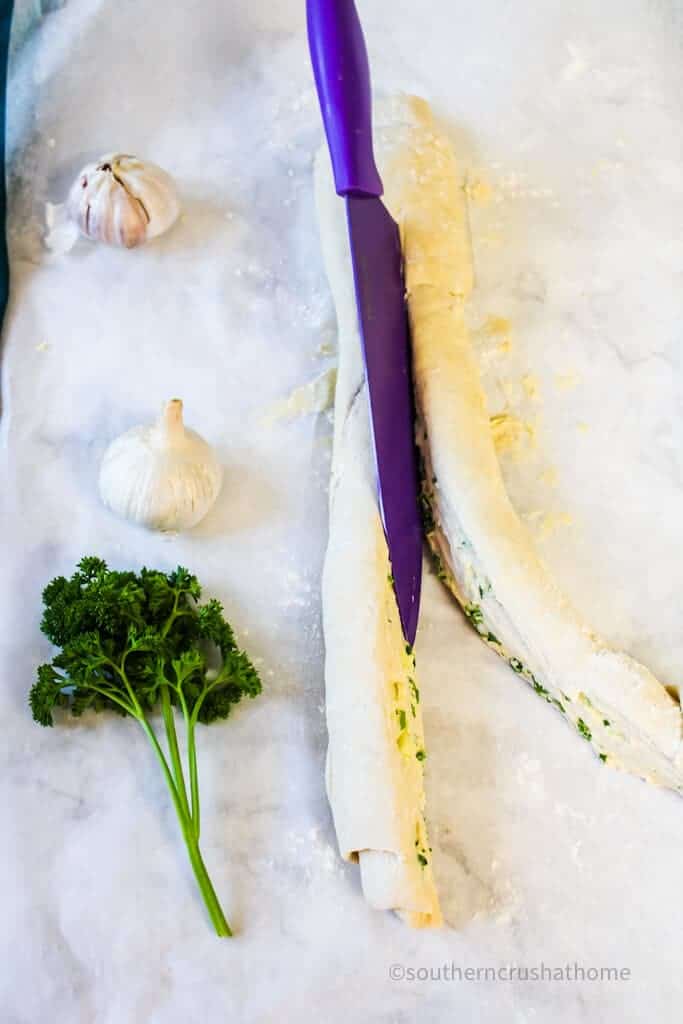 cutting garlic bread rope in half lengthwise