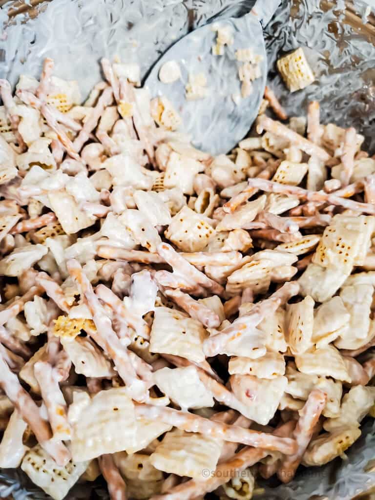 white chocolate almond bark and rice chex and pretzels mixing