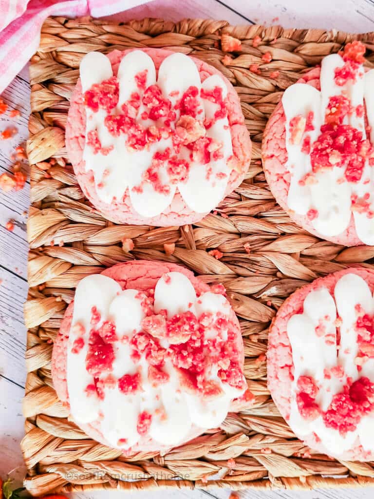 four copycat crumbl strawberry crunch cookies on woven platter