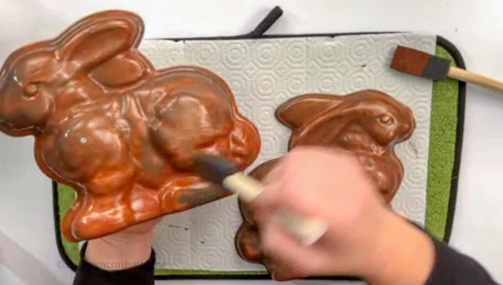 applying bronze paint to bunny cake pan