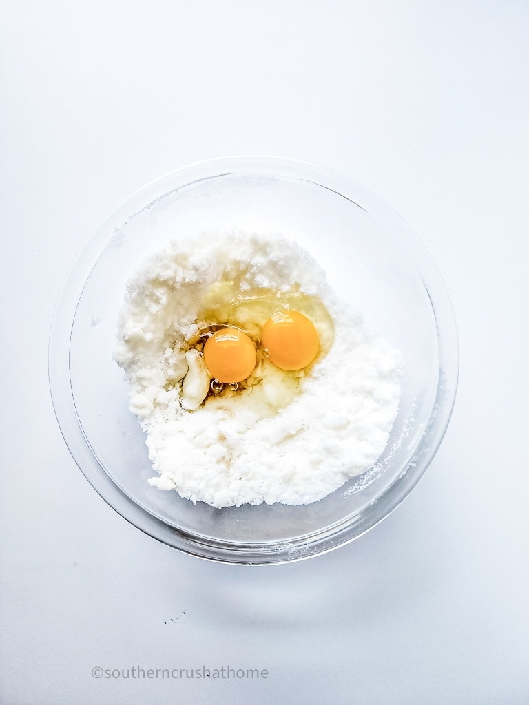 mixing eggs and butter with flour and sugar in a bowl