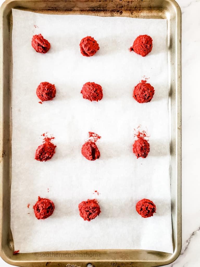 balls of red velvet cookie batter on baking sheet