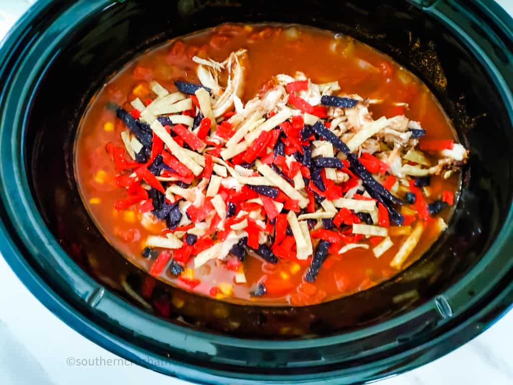 tortilla strips on top of Chicken Taco Soup in crockpot