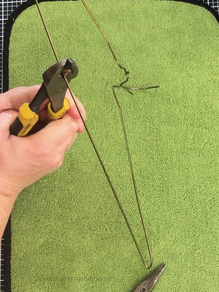 cutting coat hanger in half with wire snips