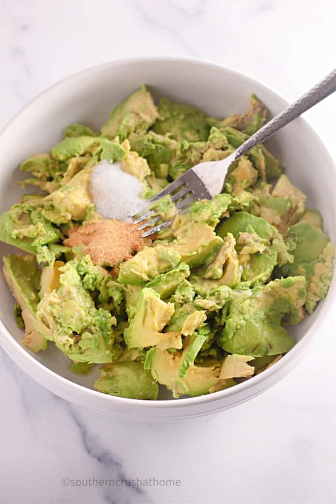 mixing garlic and salt into avocado mixture