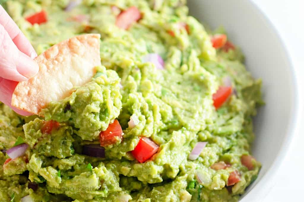 dipping a chip in homemade guacamole