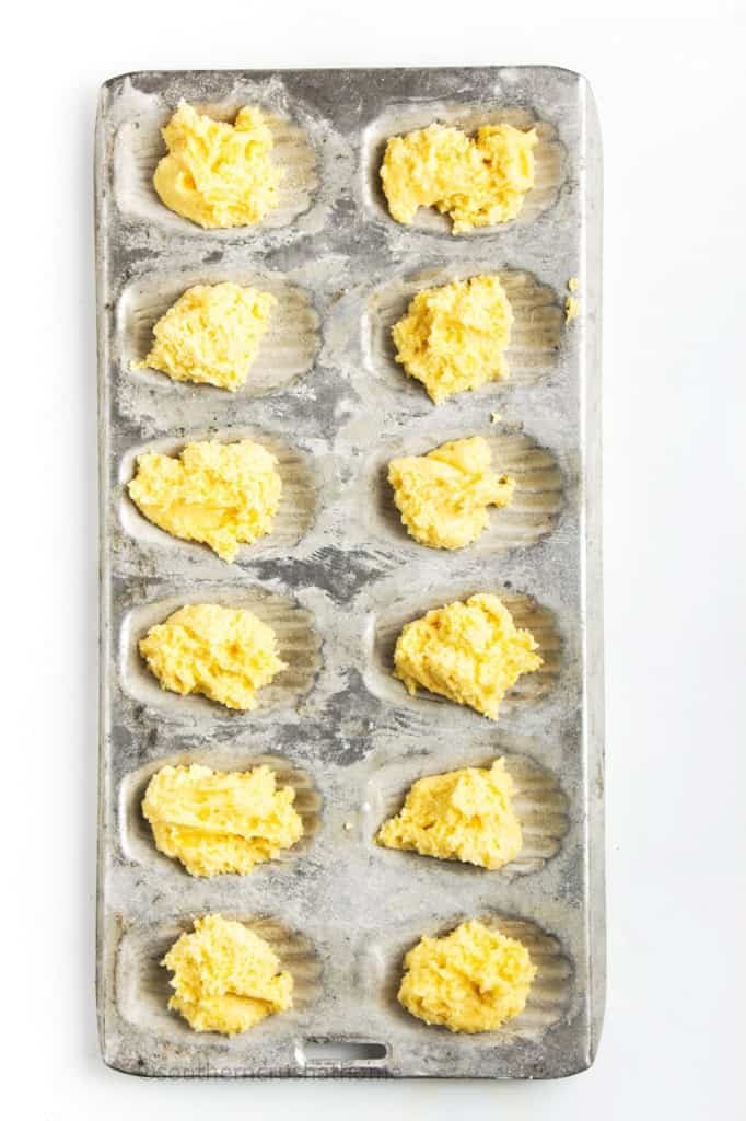 adding scoops of Madeleine Cookie batter to baking pan