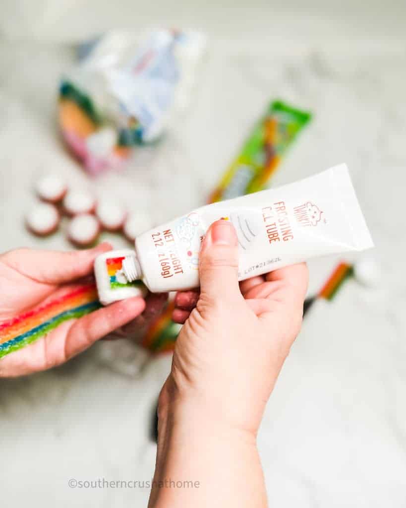 adding icing to rainbow candy