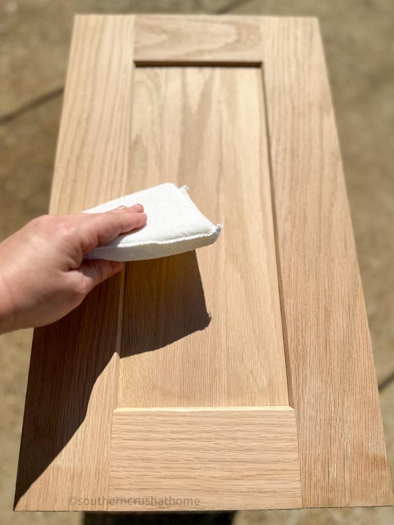 wiping clean wood dust from sanding