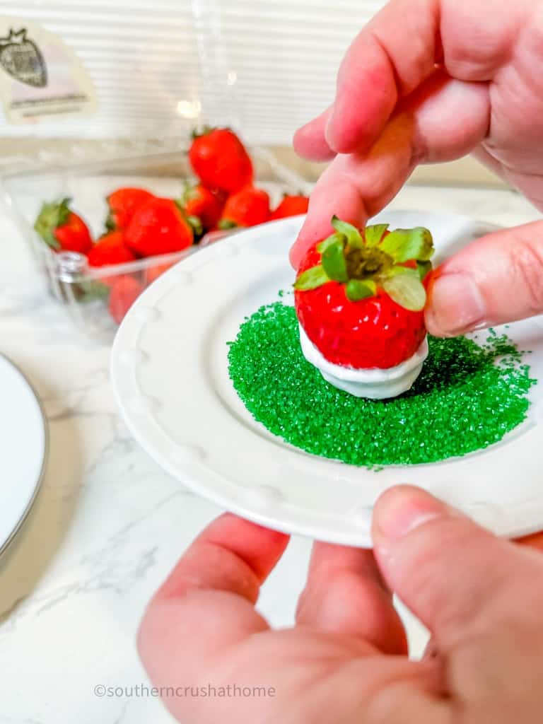 dippiing strawberry with creme into sprinkles