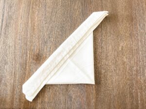folding napkin at base of triangle
