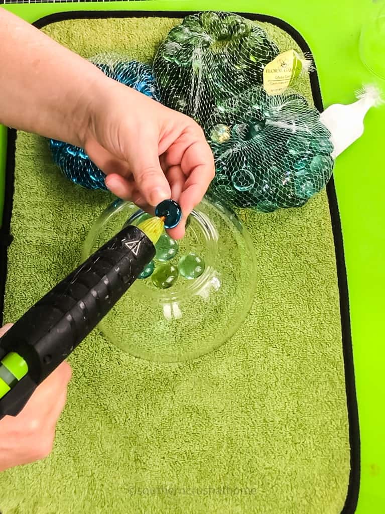 hot gluing colored glass gems to dollar tree bowl