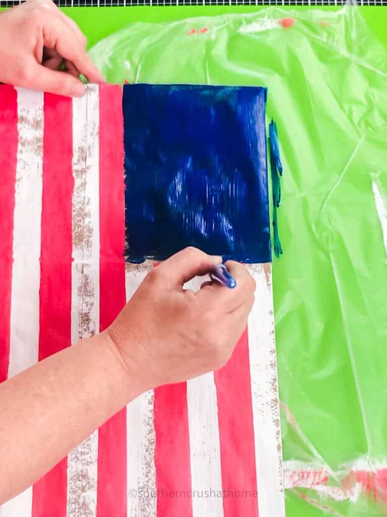 painting blue square onto american flag