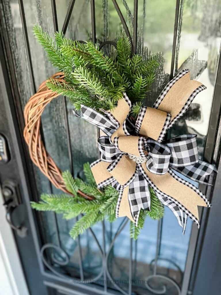 overhead view of finished multi-layer buffalo check bow on a grapevine wreath hanging on my front door