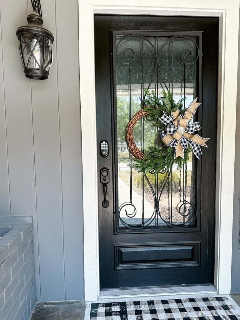 view of finished multi-layer buffalo check bow on a grapevine wreath hanging on my front door