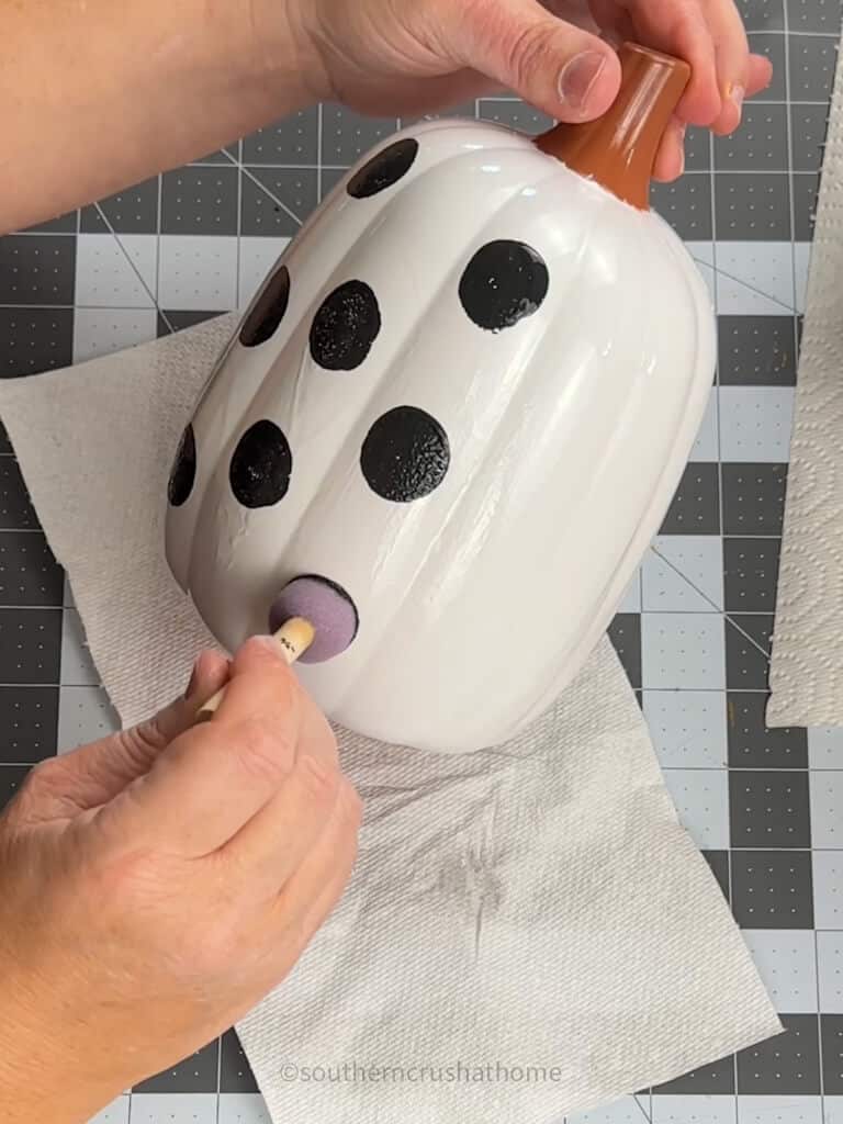 adding black polka dots to a white pumpkin