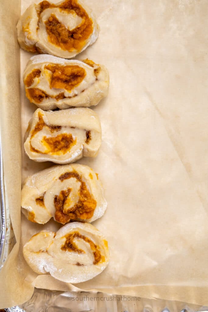 pumpkin cinnamon roll slices on parchment paper