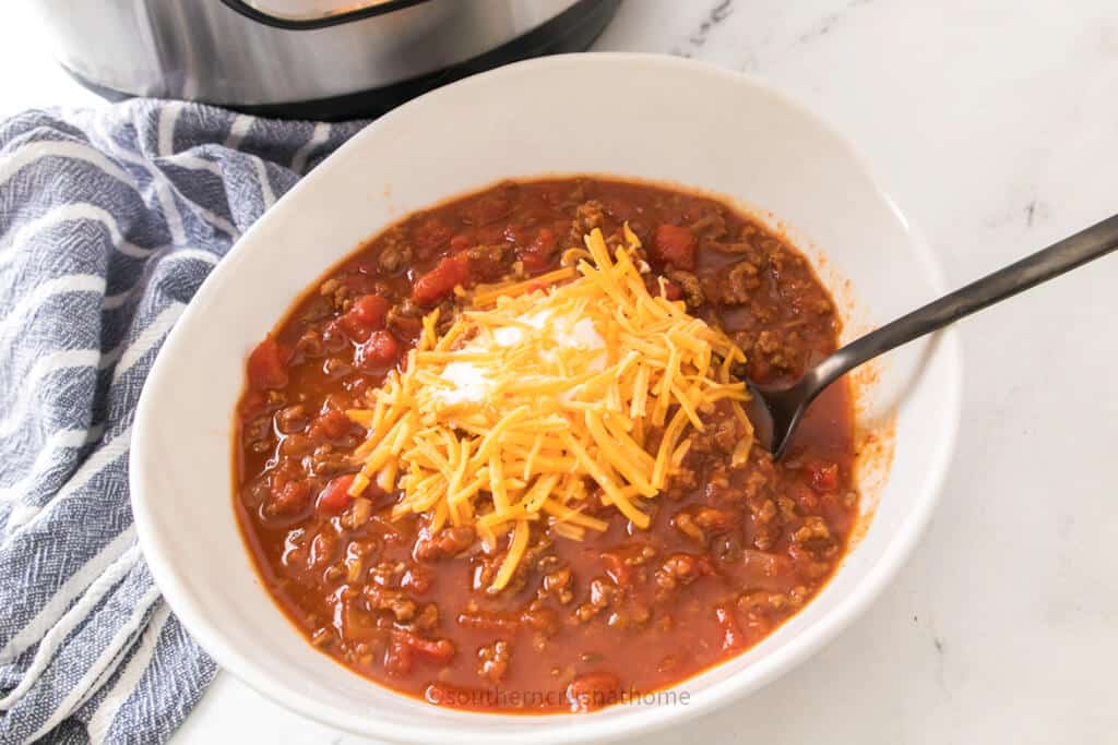 cheese and sour cream on chili in bowl