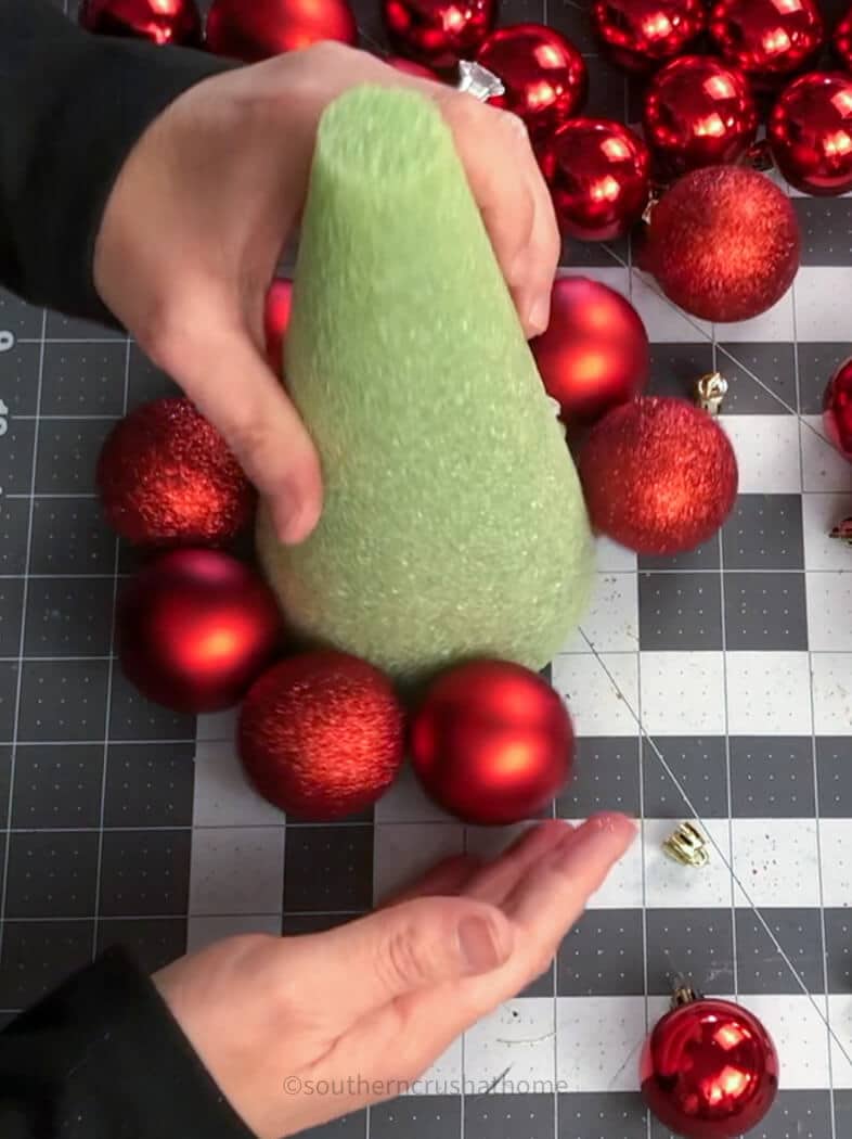 adding ball ornaments to cone