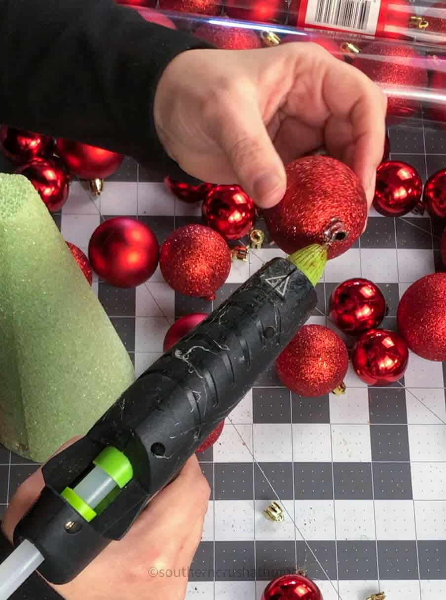 hot gluing ball ornaments to cone