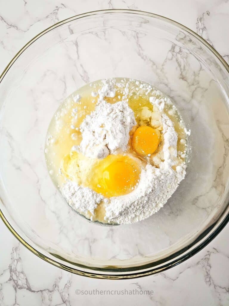 adding eggs to mixing bowls