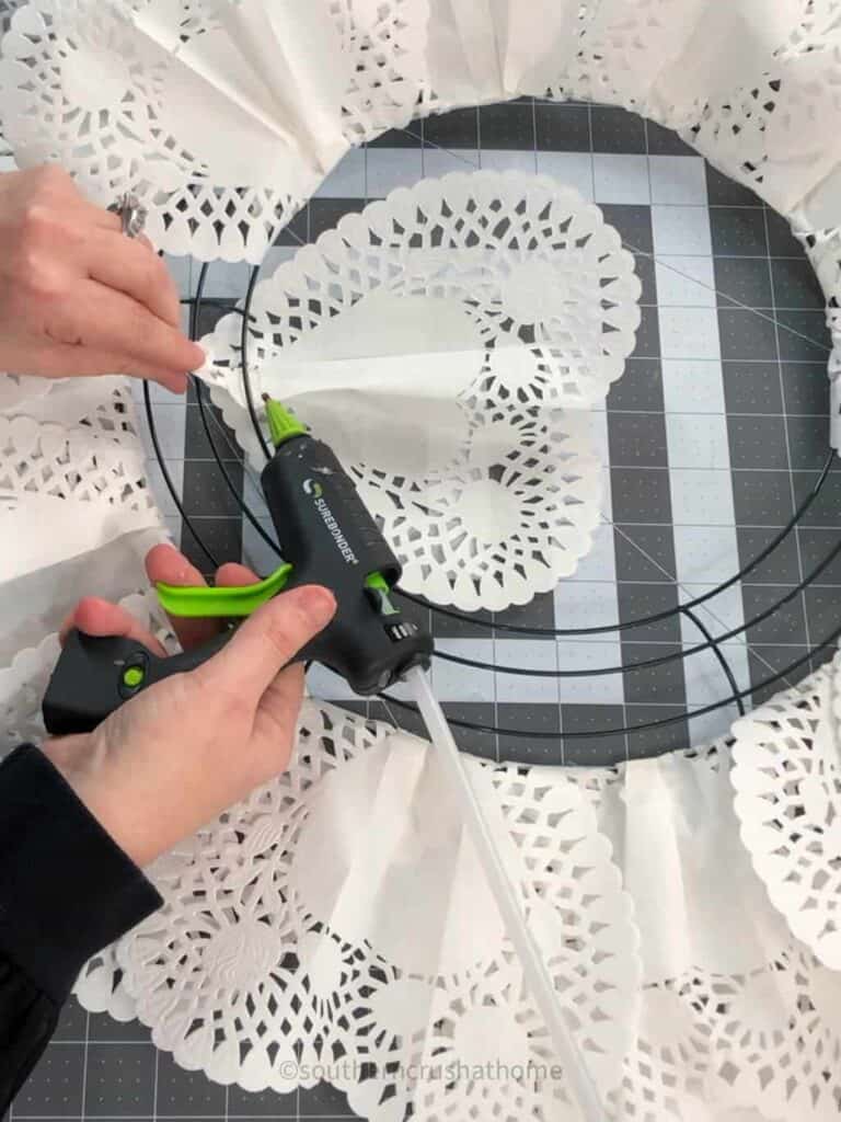 gluing paper heart doily to wreath frame