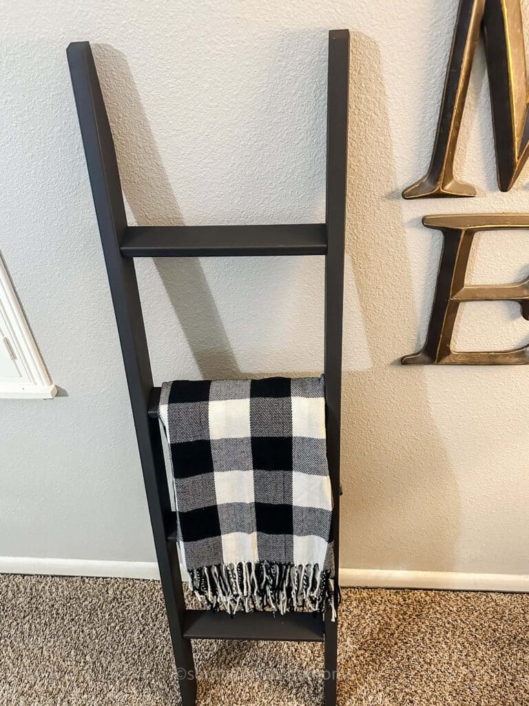 buffalo check blanket draped over a blanket ladder