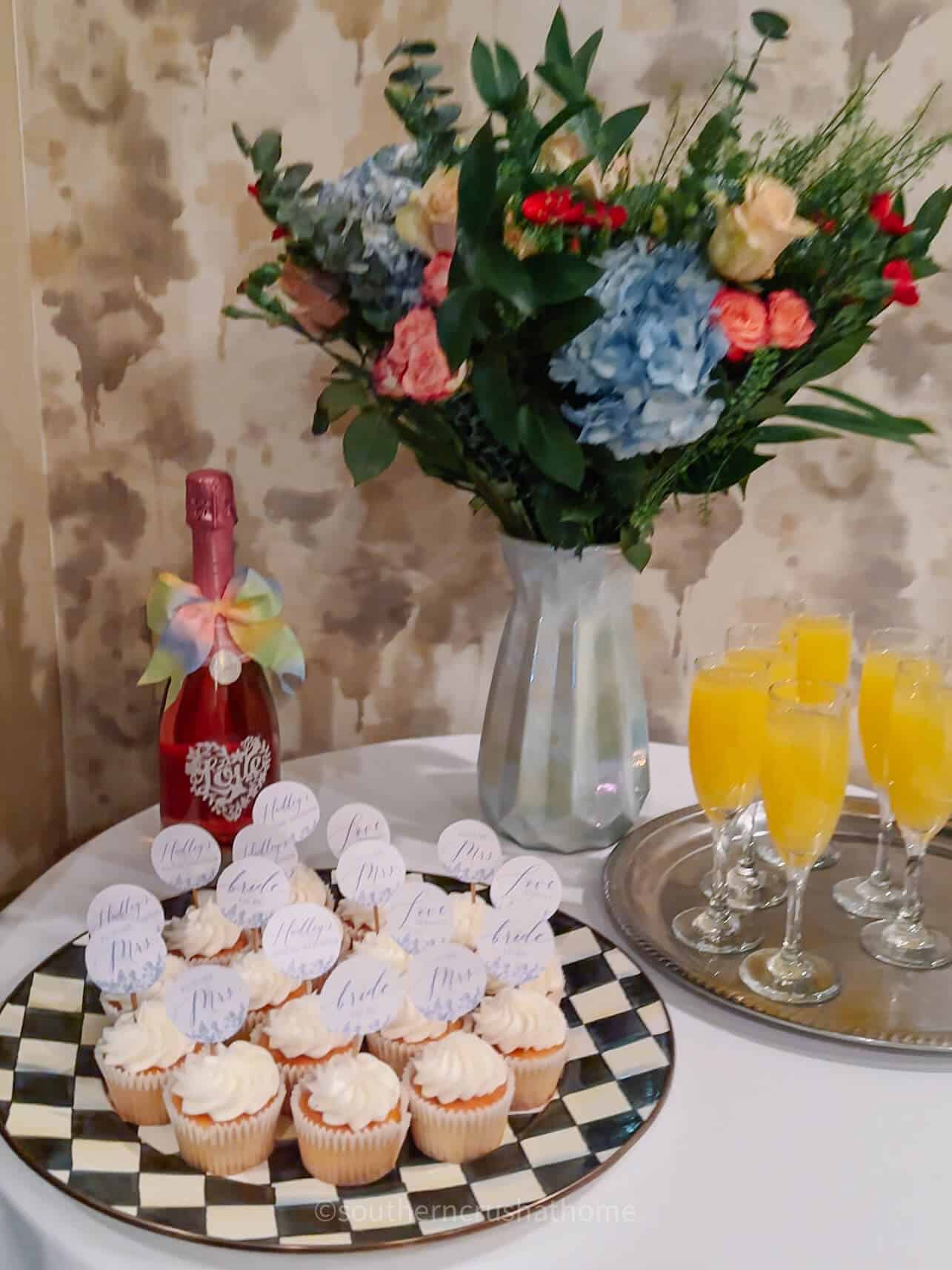 cupcakes displayed at shower on a table with flowers
