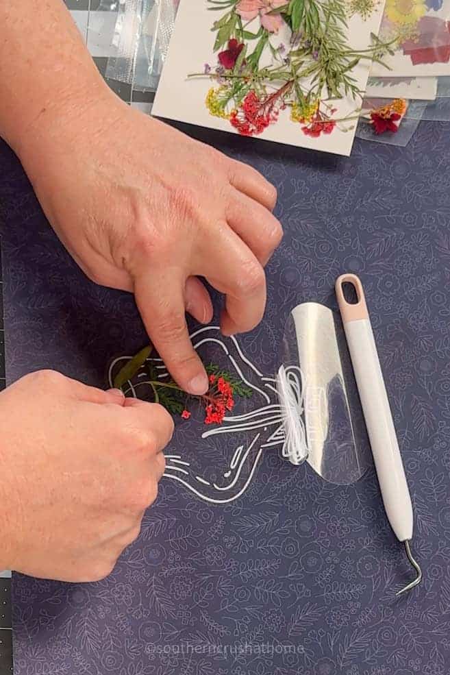 placing dried flowers on sticker