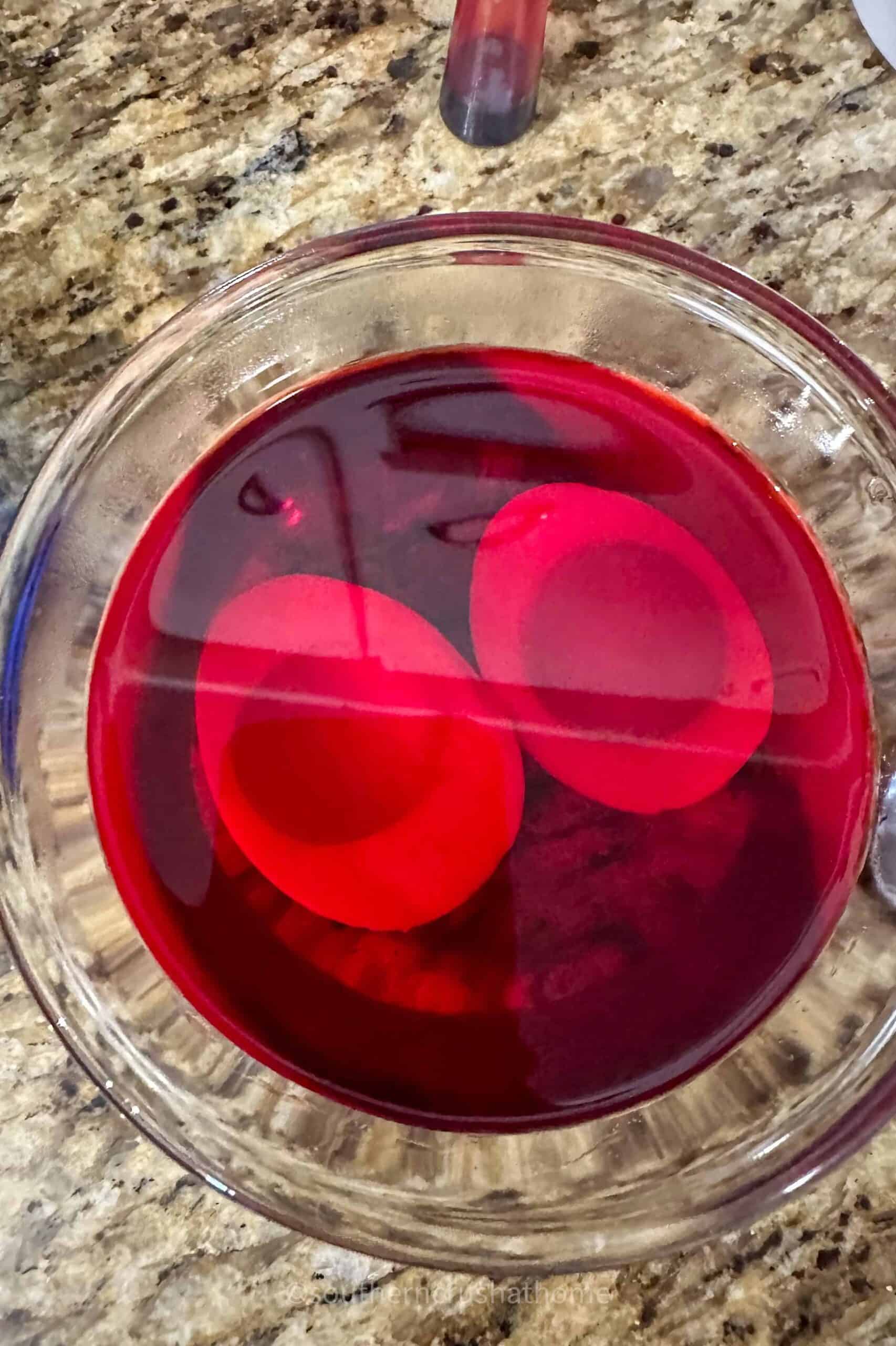 egg white halves soaking in red coloring