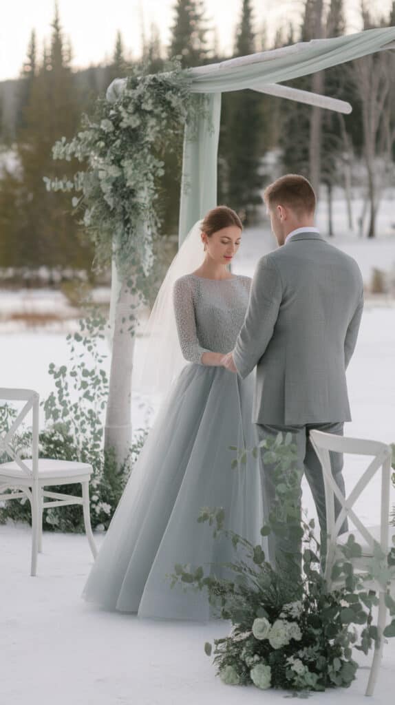 Couple in gray and sage attire during a serene winter wedding ceremony