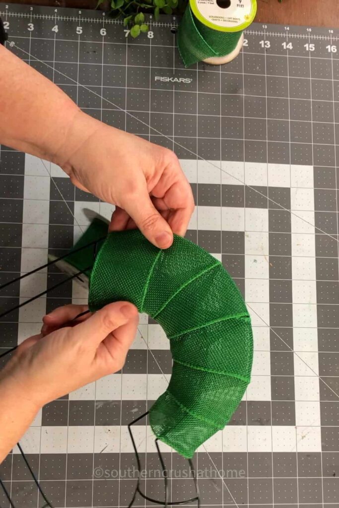 wrapping ribbon around a heart wreath