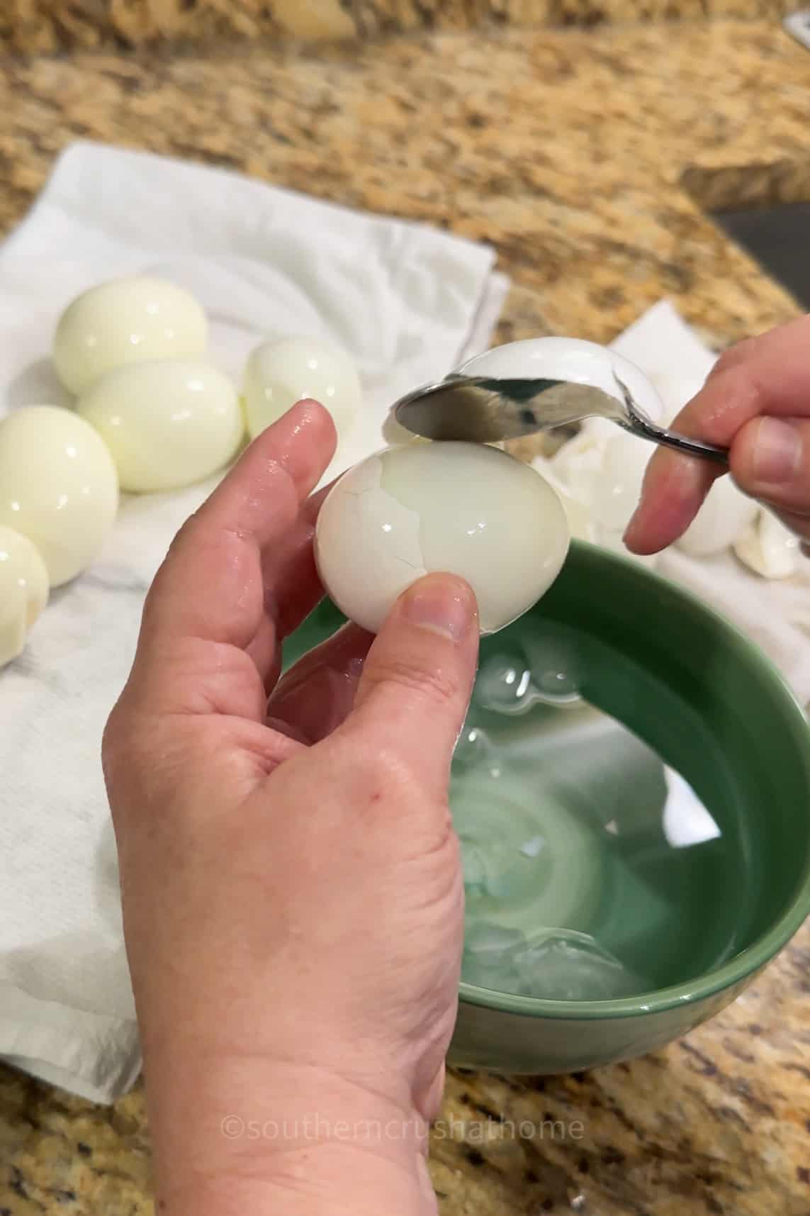 peeling a boiled egg with a spoon