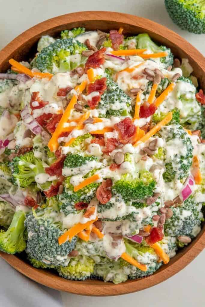 Broccoli salad with carrots, bacon, and sunflower seeds in a wooden bowl