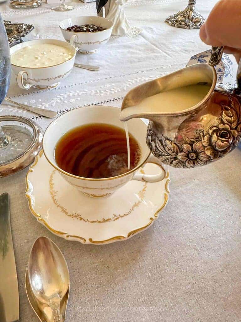 creamer pouring into hot tea cup